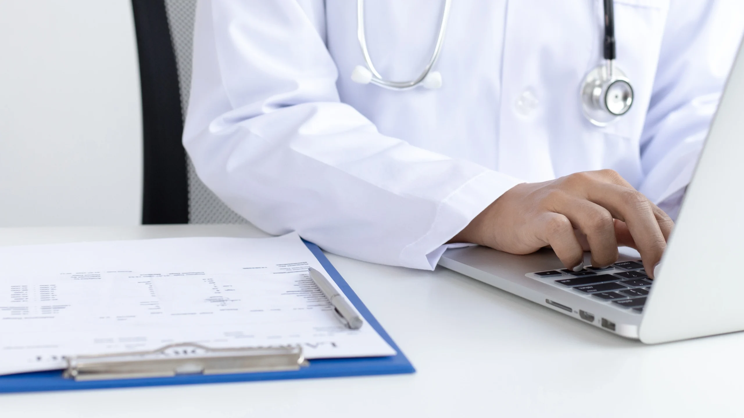 Clinician reviewing a patient chart and billing software for a CPT 11750 nail procedure claim