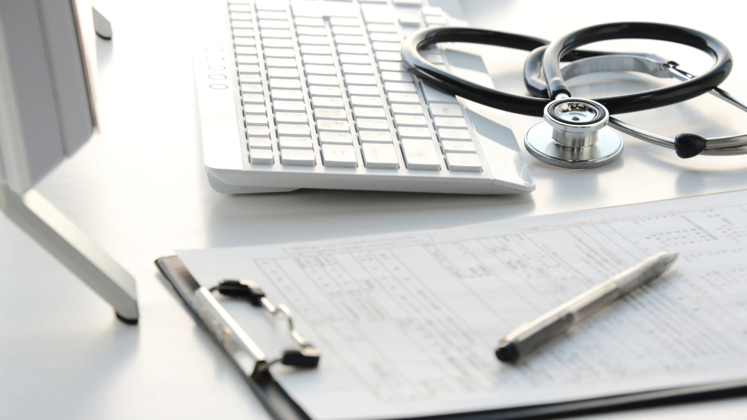 Medical billing claim form, stethoscope, and keyboard on a desk representing 2027 Medicare fee schedule changes for podiatry