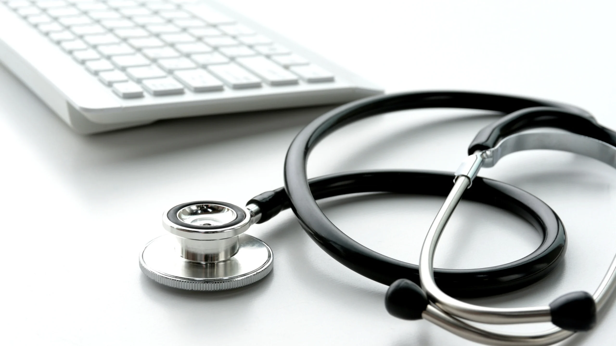 Stethoscope and keyboard on a desk representing Medicare therapeutic shoe billing documentation review